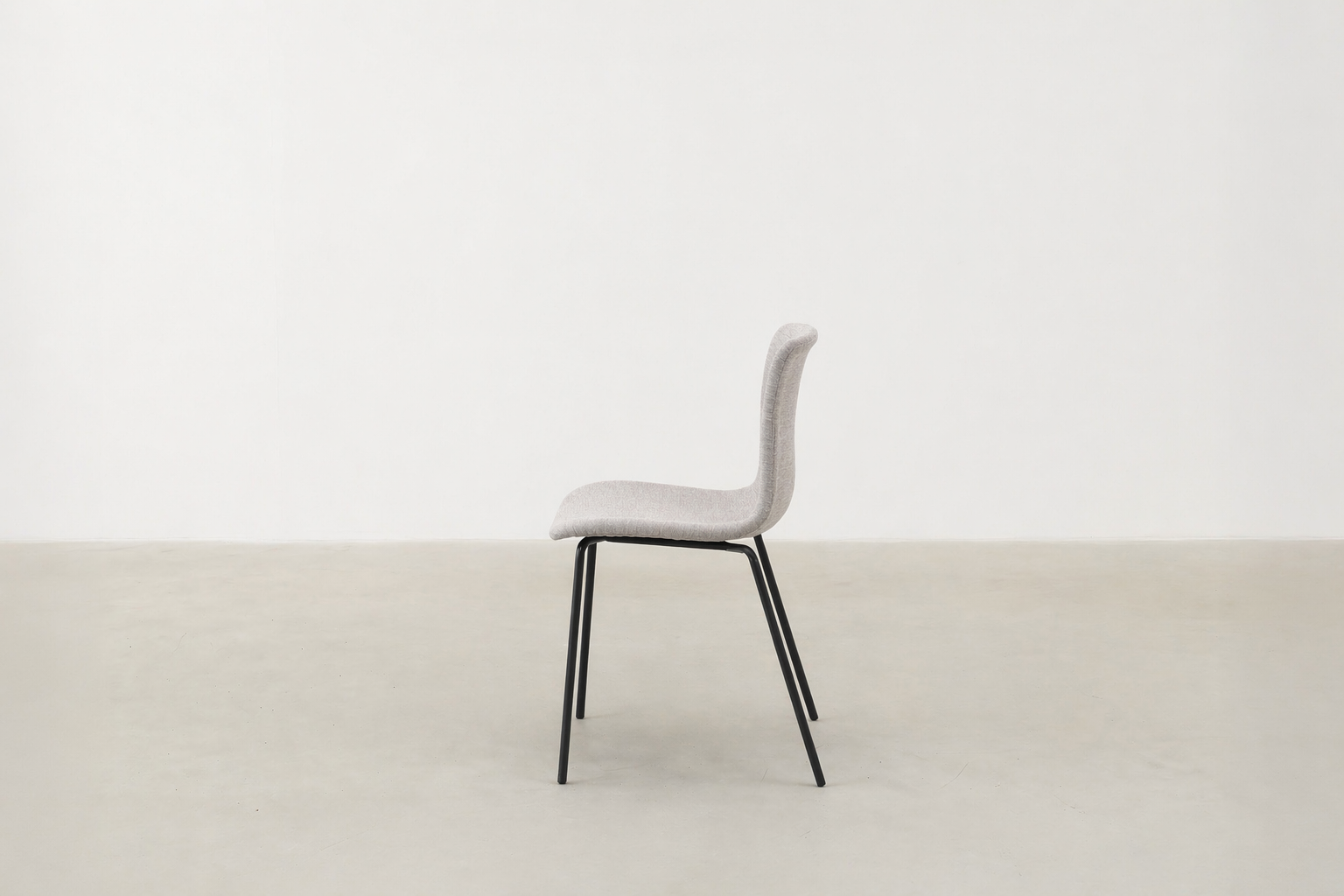Minimalist dining chair with black metal legs and soft curved seat – Caprae chair for Canadian spaces