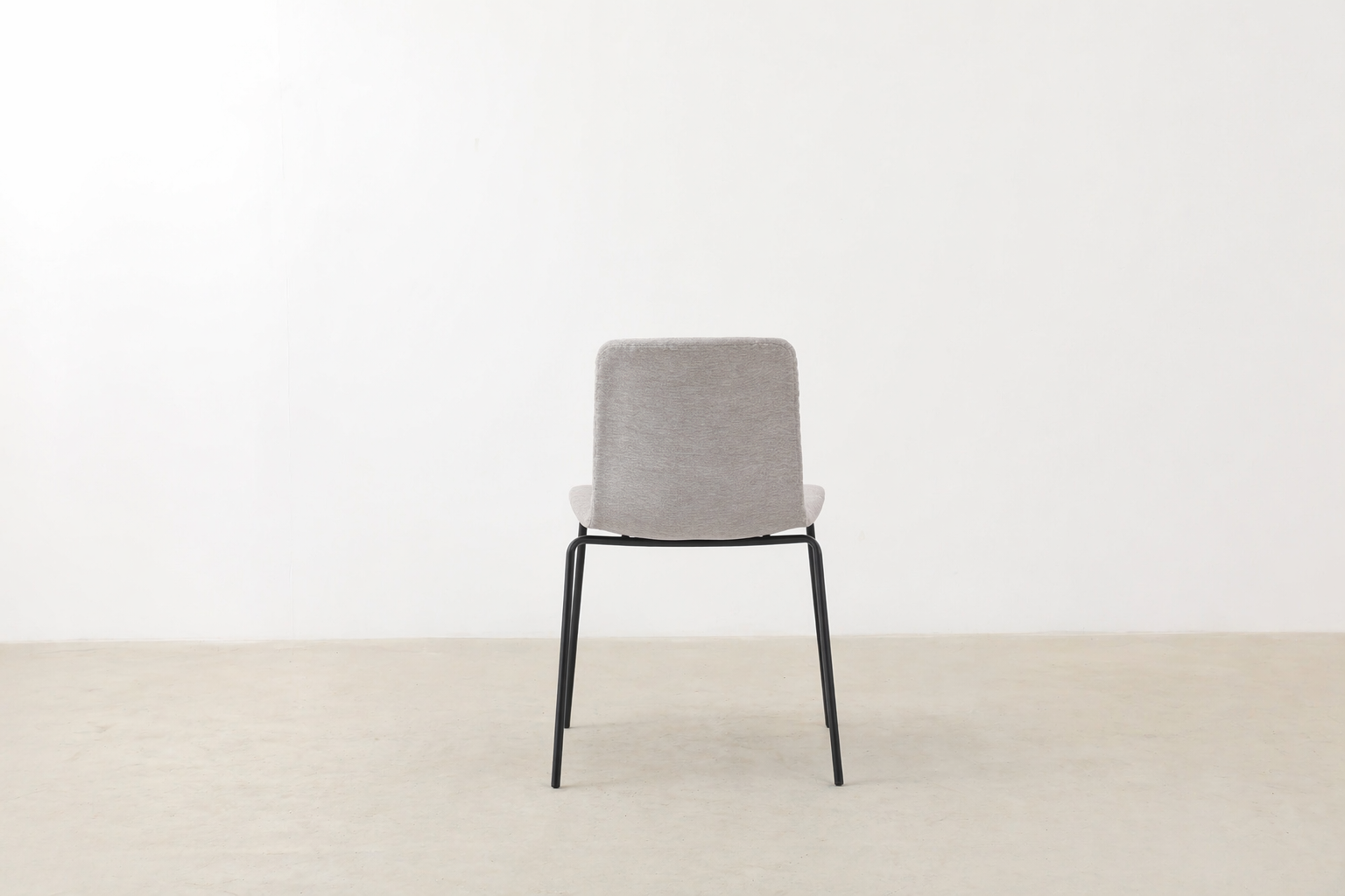 Minimalist dining chair with black metal legs and soft curved seat – Caprae chair for Canadian spaces