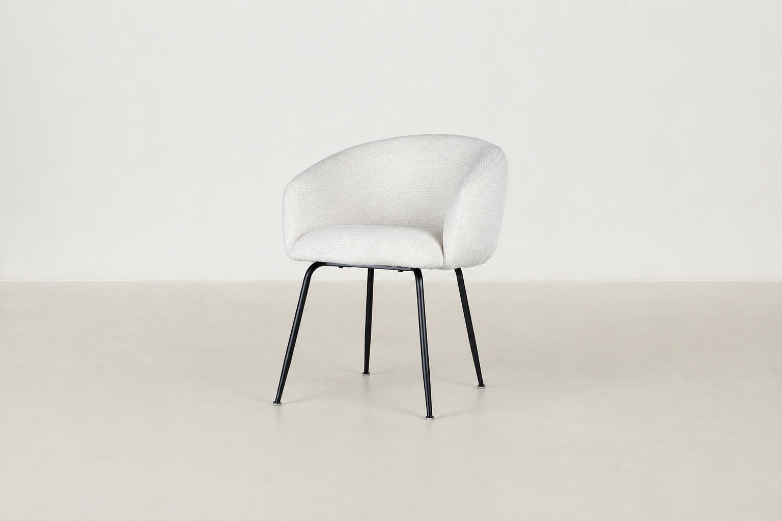 Chic boucle dining chair with curved backrest and black steel legs, styled for a modern dining space.