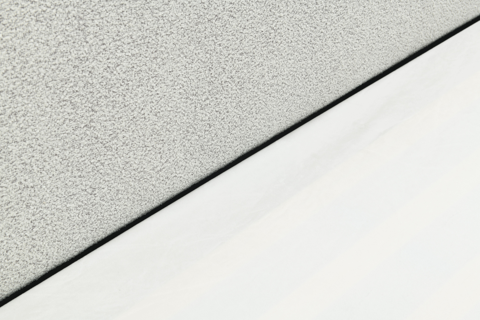Sable light grey upholstered bed with rounded corners and low-profile design.