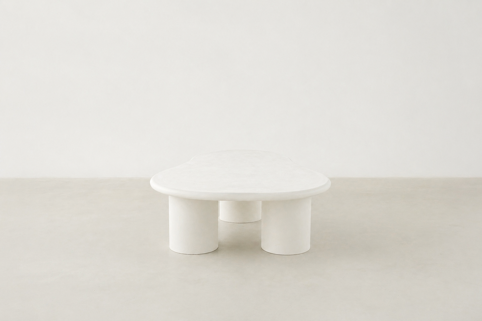 Sculpt kidney shaped coffee table in white concrete with matte finish and cylindrical legs, Japandi modern style.