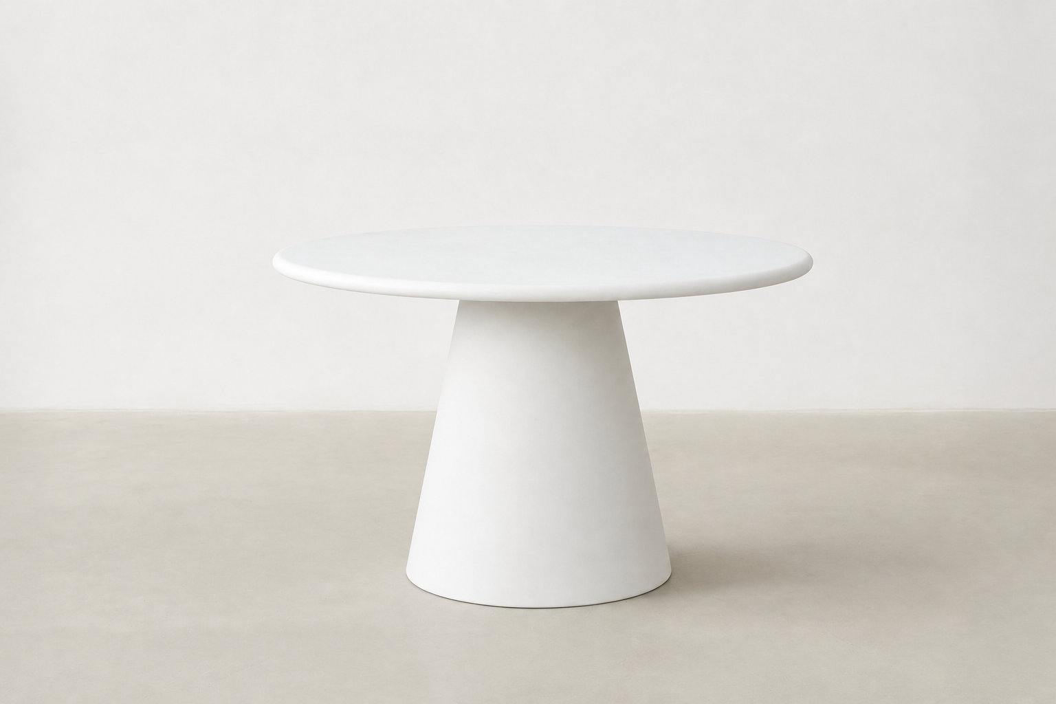 Stratum round pedestal dining table with white-cream concrete finish and sculptural cone base in Japandi style.