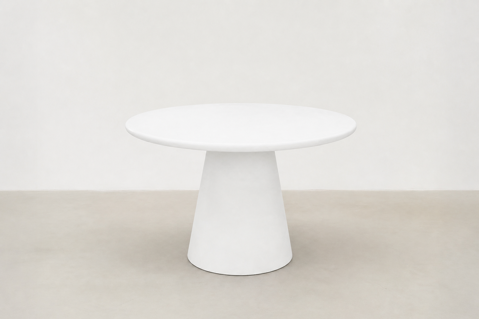 Stratum round pedestal dining table with white-cream concrete finish and sculptural cone base in Japandi style.