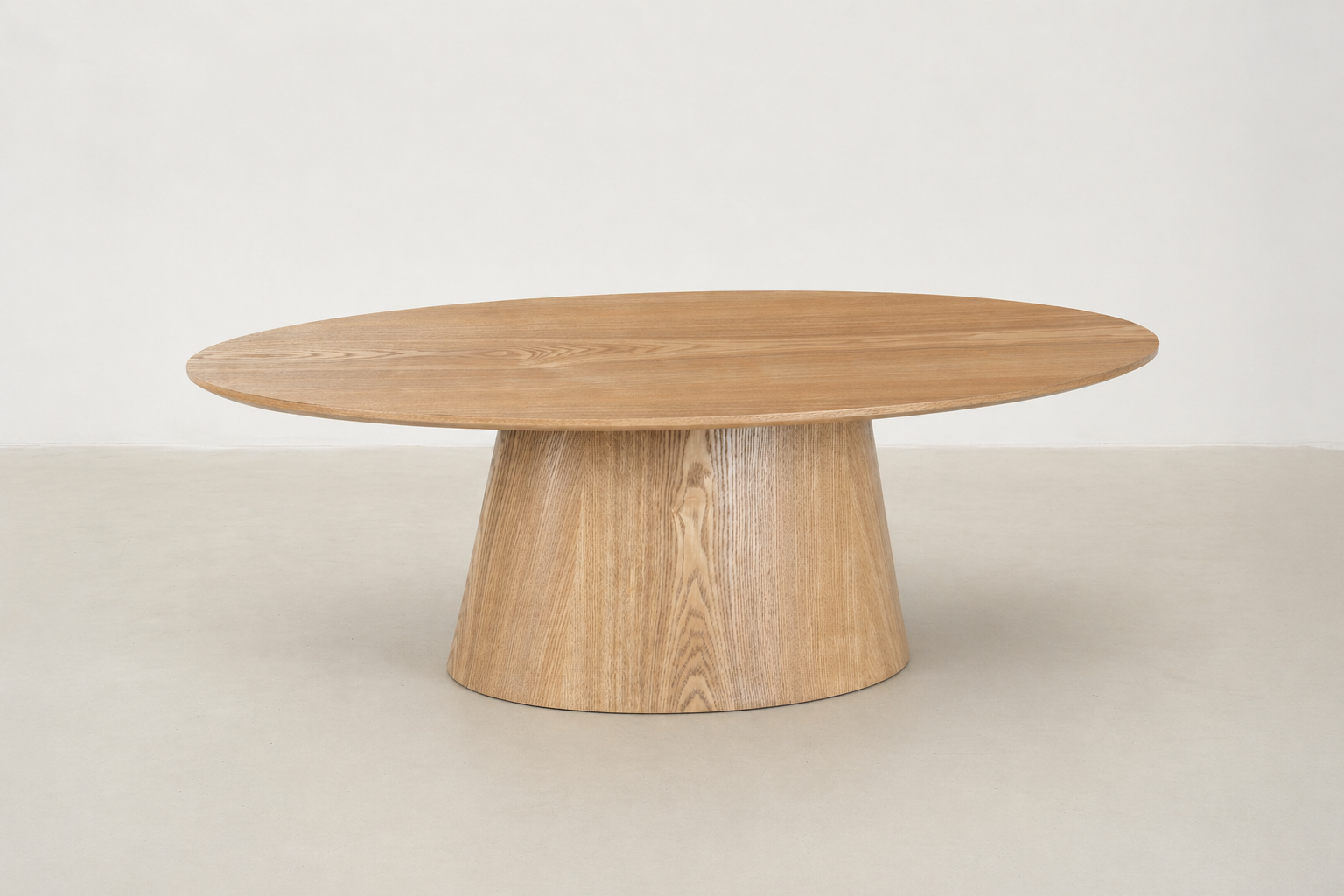 Side view of Zen Coffee Table showing its curved oak pedestal base and low-profile silhouette