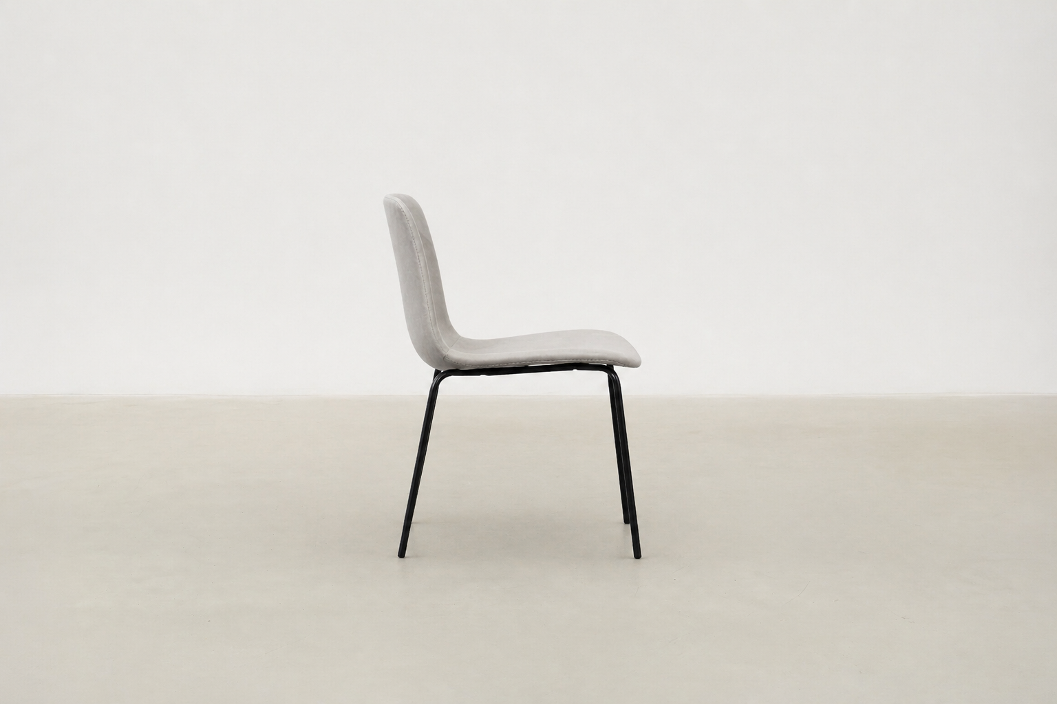 Minimalist dining chair with black metal legs and soft curved seat – Caprae chair for Canadian spaces
