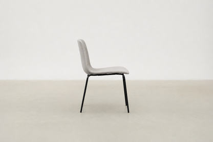 Minimalist dining chair with black metal legs and soft curved seat – Caprae chair for Canadian spaces
