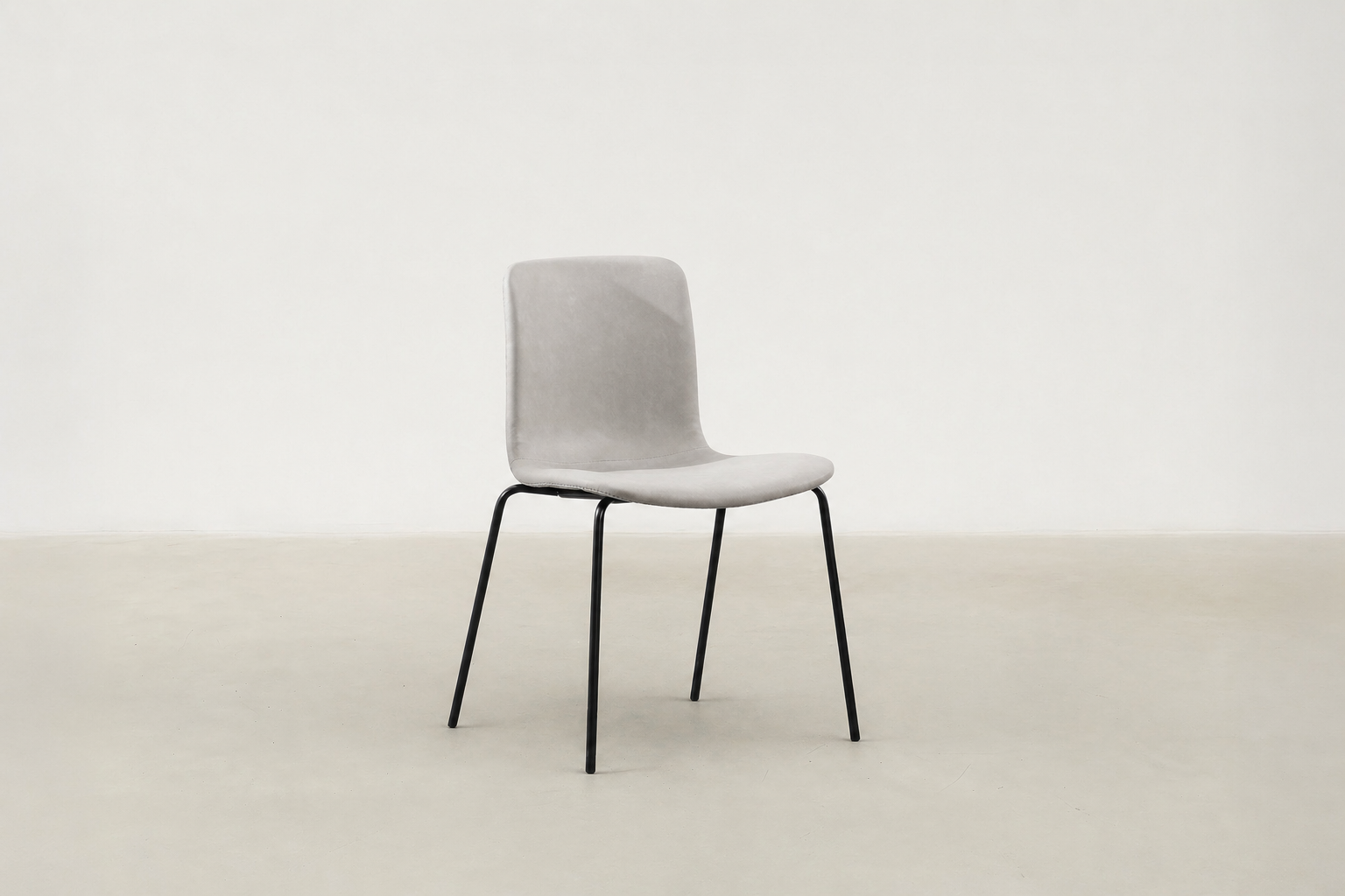 Minimalist dining chair with black metal legs and soft curved seat – Caprae chair for Canadian spaces