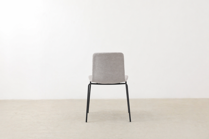 Minimalist dining chair with black metal legs and soft curved seat – Caprae chair for Canadian spaces