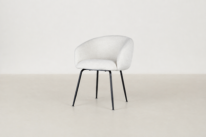 Chic boucle dining chair with curved backrest and black steel legs, styled for a modern dining space.