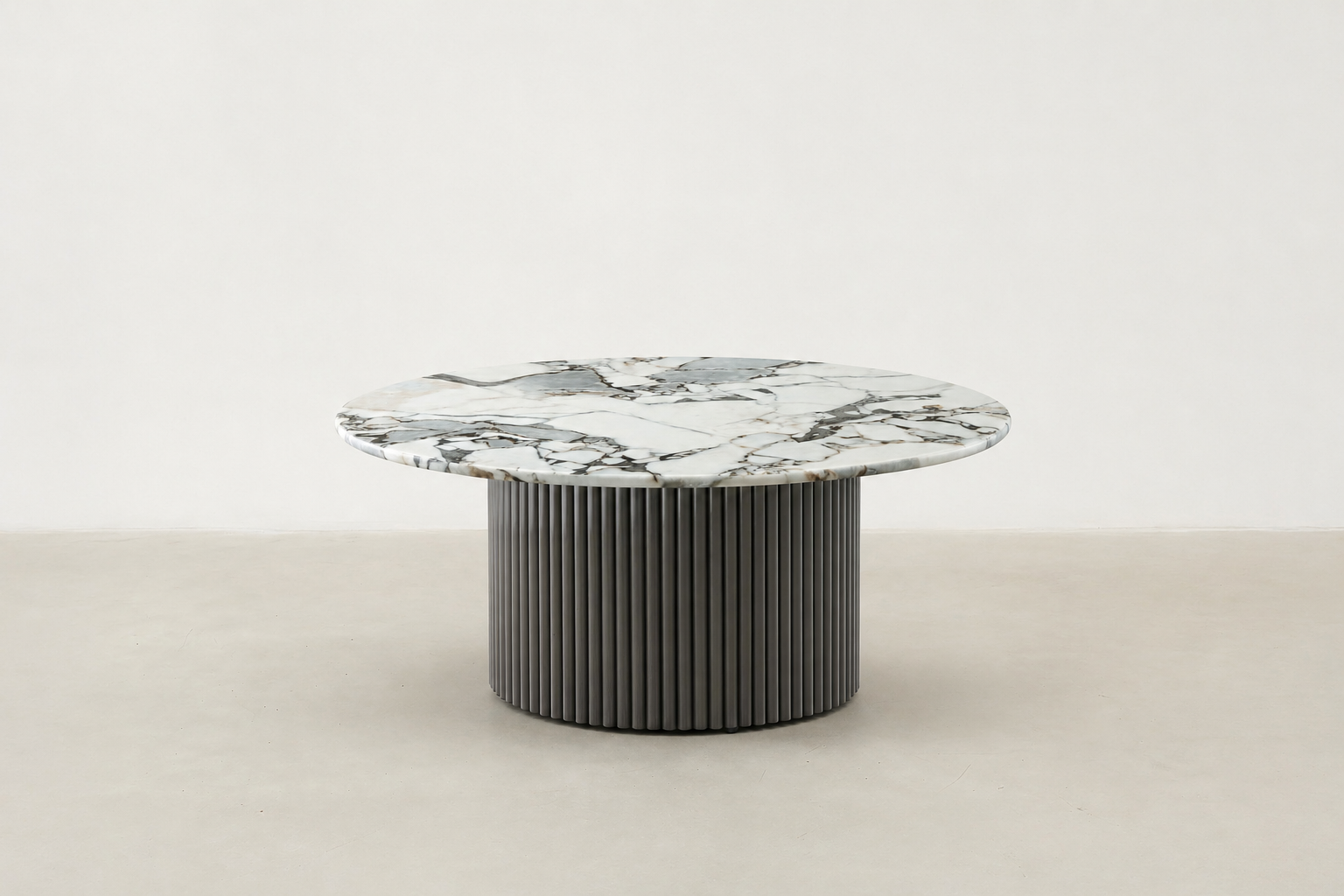 White round marble coffee table with veining and fluted black metal base – modern Canadian living room.