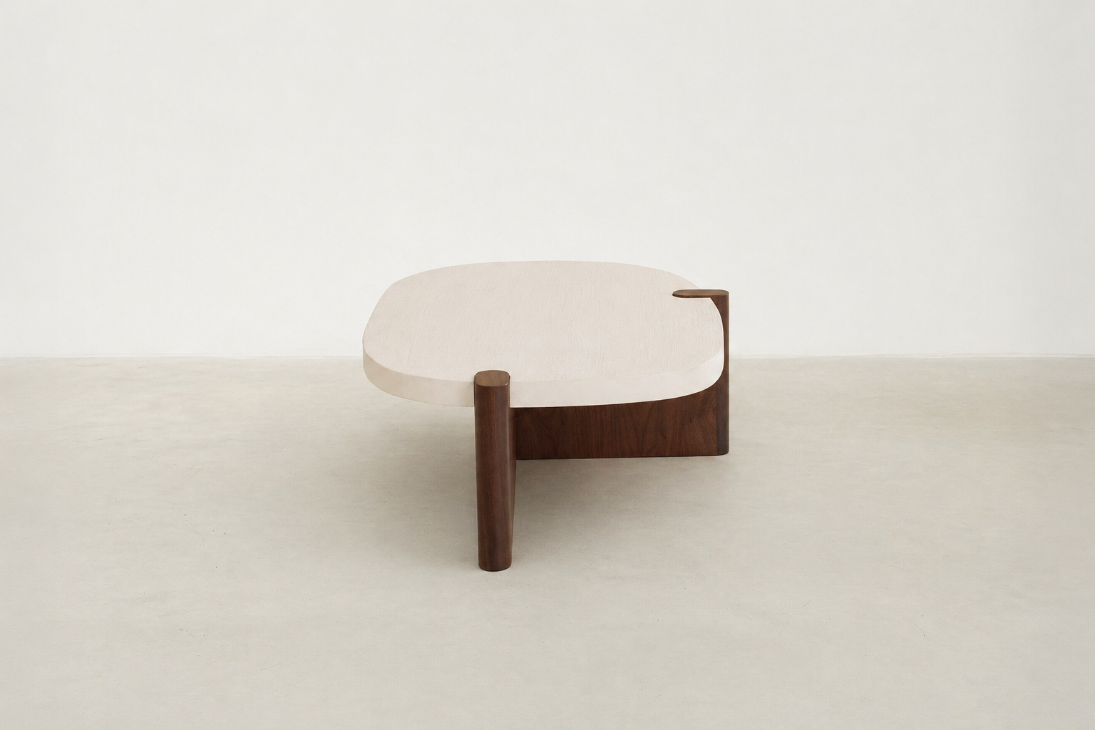 Nordli sculptural coffee table with walnut base and asymmetrical concrete-style top.