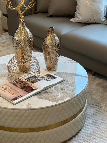 Sassaste luxury round coffee table with faux-marble top, quilted PU leather base, and gold accent banding.