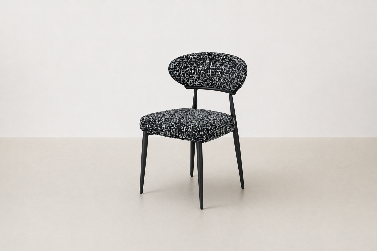 "Savvy black and white tweed upholstered dining chair with black powder-coated legs and curved backrest.
"