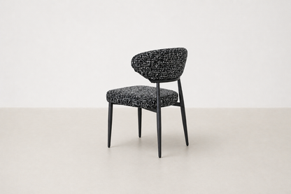 "Savvy black and white tweed upholstered dining chair with black powder-coated legs and curved backrest.
"
