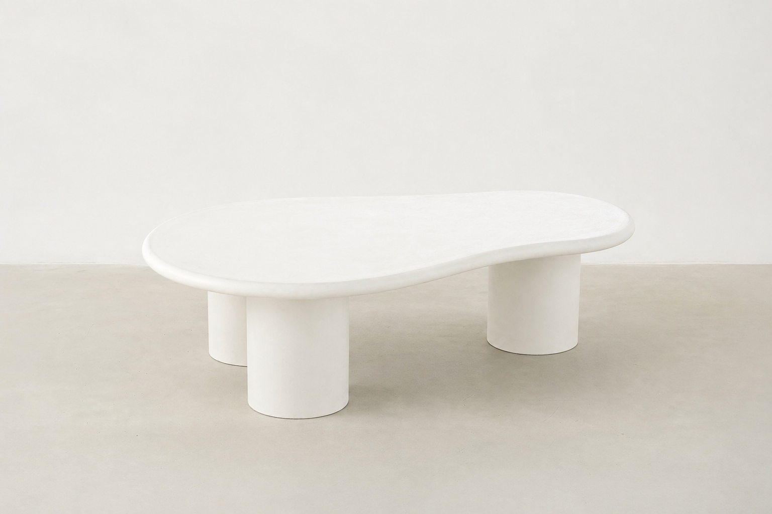 Sculpt kidney shaped coffee table in white concrete with matte finish and cylindrical legs, Japandi modern style.