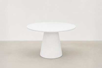 Stratum round pedestal dining table with white-cream concrete finish and sculptural cone base in Japandi style.