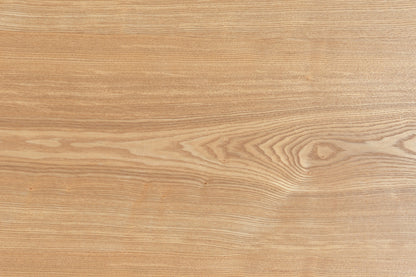 Side view of Zen Coffee Table showing its curved oak pedestal base and low-profile silhouette